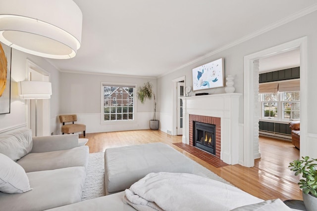 living area featuring light wood finished floors, a wealth of natural light, and crown molding