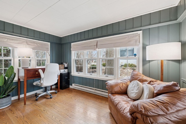 office space with light wood finished floors and a baseboard heating unit