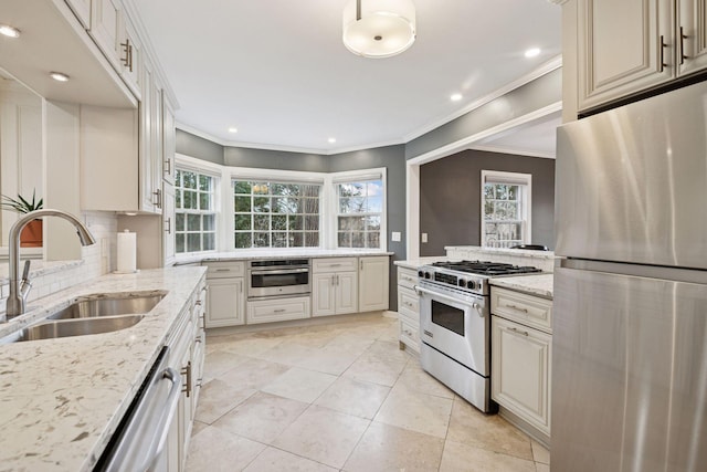 kitchen with stainless steel appliances, tasteful backsplash, ornamental molding, a sink, and light stone countertops