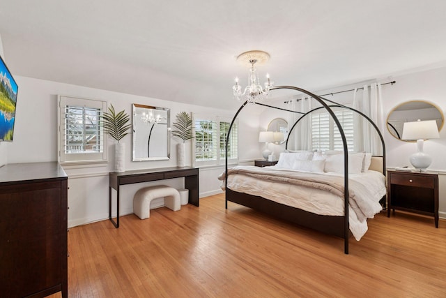 bedroom featuring light wood-type flooring, baseboards, and a chandelier