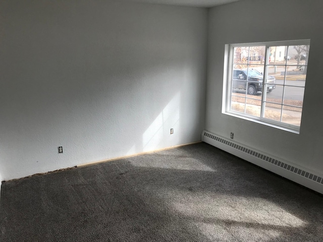 carpeted spare room with baseboard heating