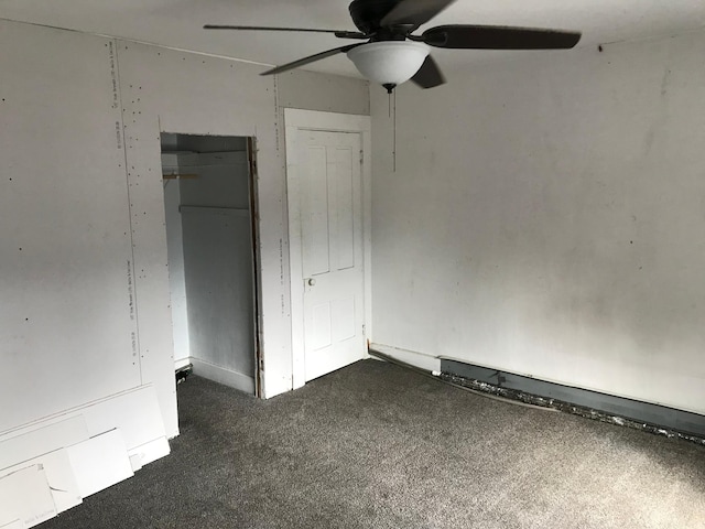 unfurnished bedroom with a ceiling fan, dark colored carpet, and a closet