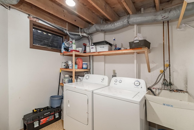 washroom with laundry area, a sink, and independent washer and dryer