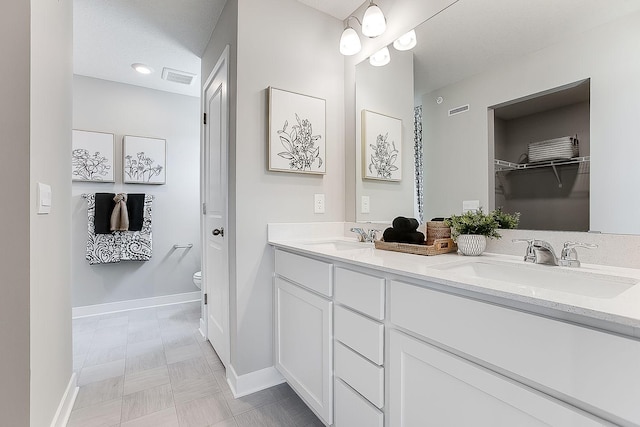 full bathroom featuring double vanity, visible vents, toilet, and a sink