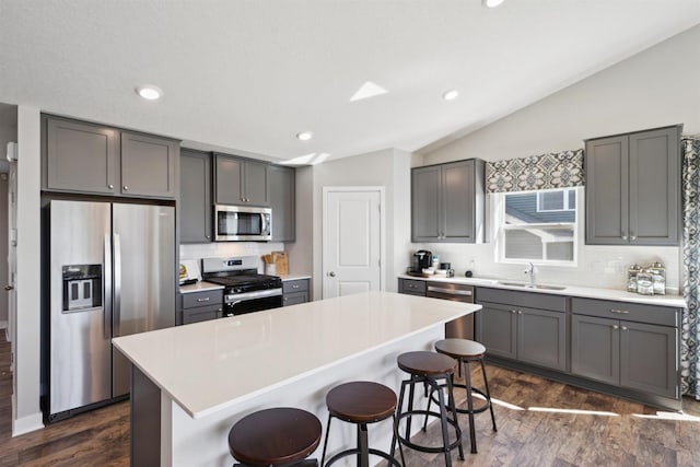 kitchen featuring light countertops, appliances with stainless steel finishes, a breakfast bar area, and a center island