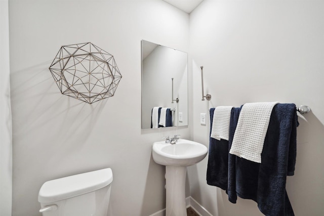 bathroom with toilet and baseboards