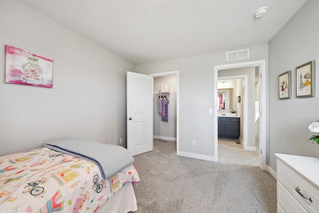 bedroom with light carpet, baseboards, a spacious closet, and visible vents