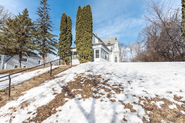 view of snowy exterior featuring a garage