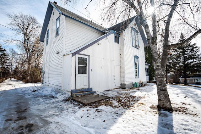 snow covered house featuring entry steps