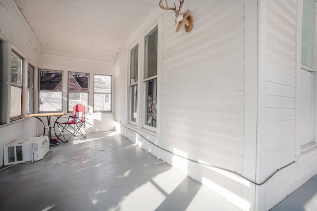 unfurnished sunroom featuring a wall mounted AC