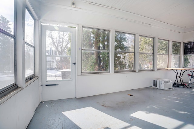 unfurnished sunroom with an AC wall unit