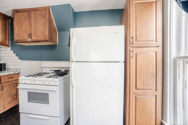 kitchen featuring brown cabinets, white appliances, and decorative backsplash