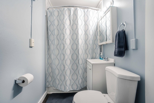 bathroom featuring toilet, shower / bath combo with shower curtain, and vanity