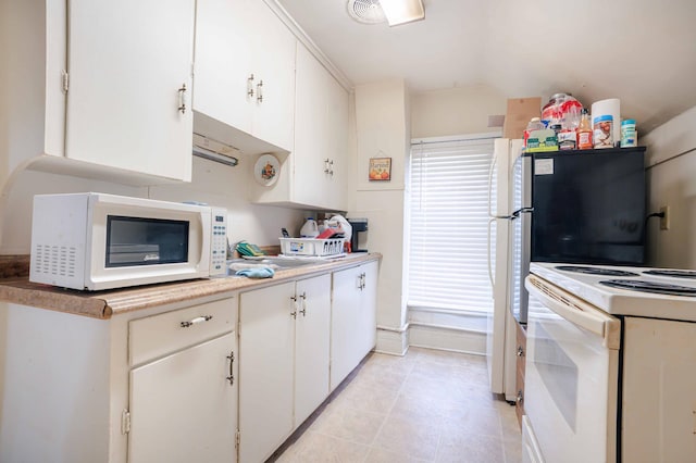 kitchen with light countertops, white appliances, white cabinetry, and plenty of natural light