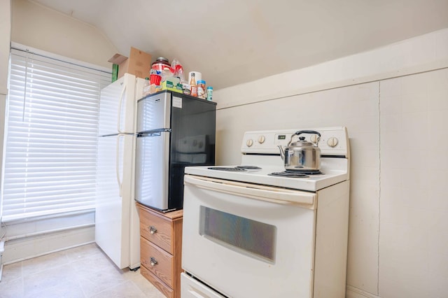 kitchen with lofted ceiling, white electric stove, and light countertops