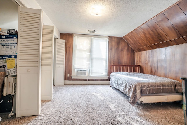 bedroom with light colored carpet, visible vents, vaulted ceiling, wooden walls, and a textured ceiling