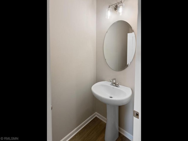 bathroom featuring a sink, baseboards, and wood finished floors