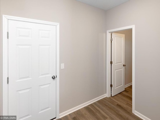 hall featuring baseboards and wood finished floors