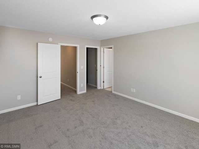 unfurnished bedroom featuring carpet and baseboards