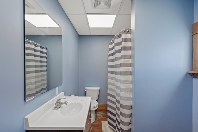 bathroom featuring visible vents, toilet, wood finished floors, a paneled ceiling, and vanity