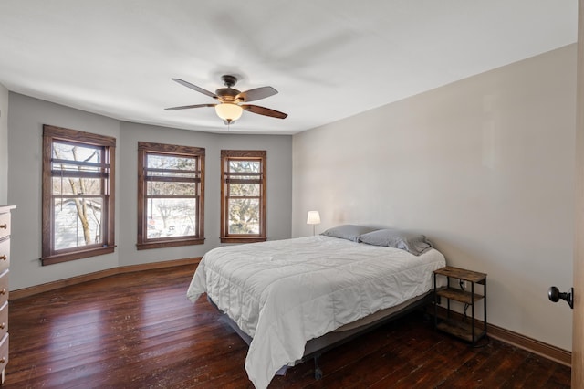 bedroom with dark wood finished floors, ceiling fan, and baseboards