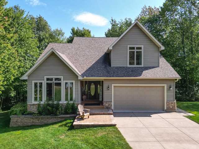 view of front facade with an attached garage, a shingled roof, stone siding, concrete driveway, and a front yard