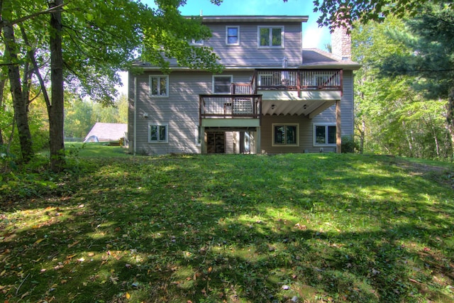 rear view of house featuring a yard, a chimney, and a wooden deck