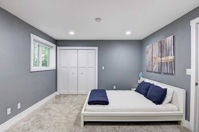 bedroom with baseboards, a closet, recessed lighting, and light colored carpet