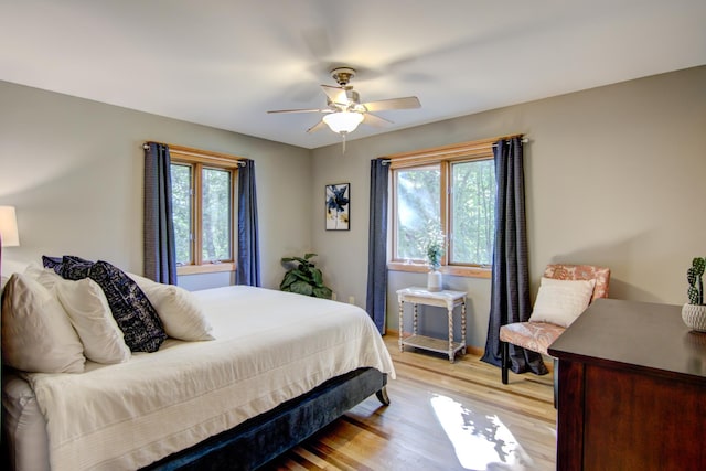 bedroom featuring light wood-type flooring, multiple windows, and ceiling fan