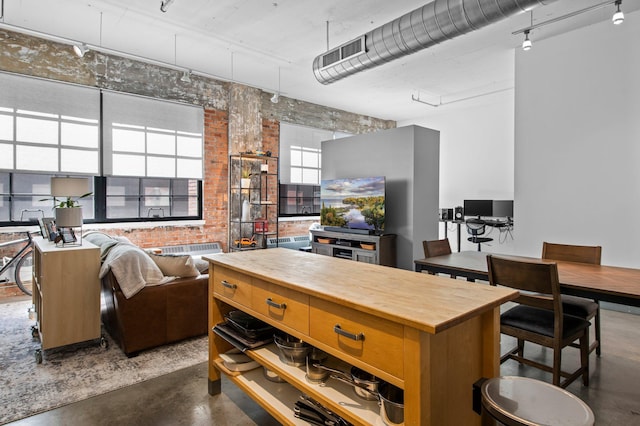 kitchen featuring brick wall, visible vents, and finished concrete floors