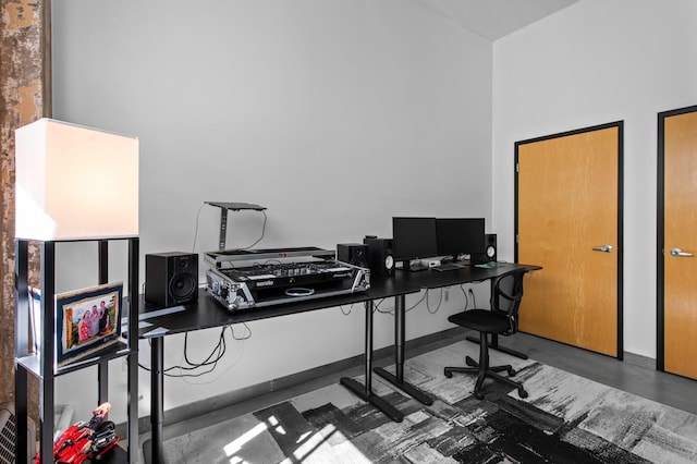 office space with finished concrete floors and a high ceiling