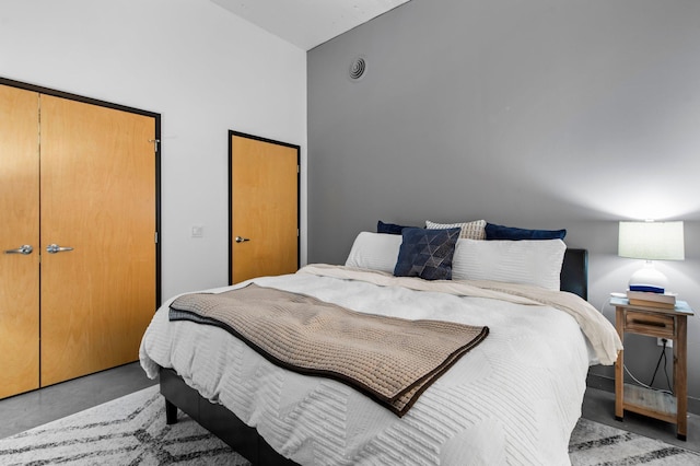 bedroom featuring concrete floors and a towering ceiling