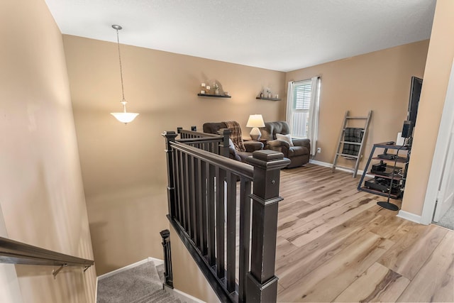 stairway with wood finished floors and baseboards