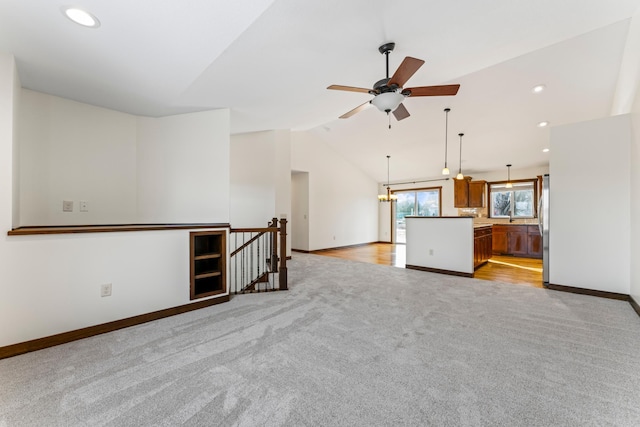 unfurnished living room featuring lofted ceiling, recessed lighting, light colored carpet, a ceiling fan, and baseboards