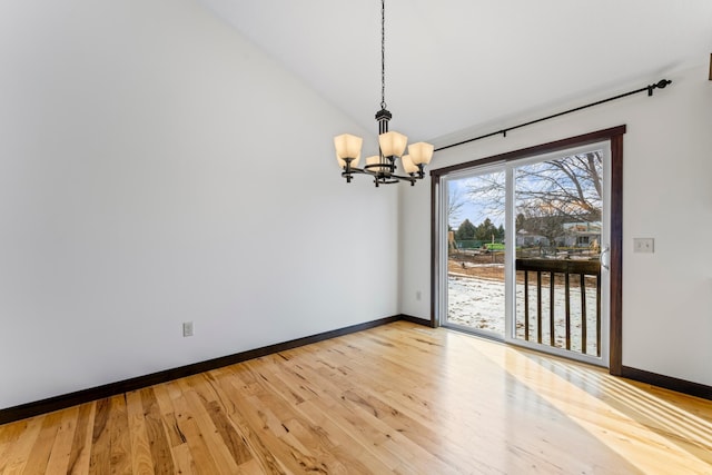 unfurnished dining area with lofted ceiling, light wood finished floors, baseboards, and a chandelier