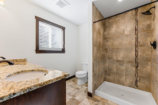 bathroom featuring toilet, visible vents, vanity, baseboards, and a shower stall