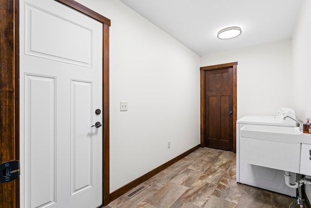 laundry area with laundry area, visible vents, baseboards, independent washer and dryer, and a sink