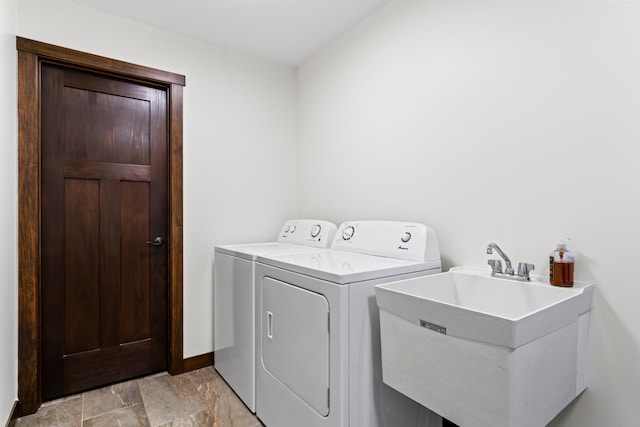 laundry area with laundry area, baseboards, a sink, and washing machine and clothes dryer