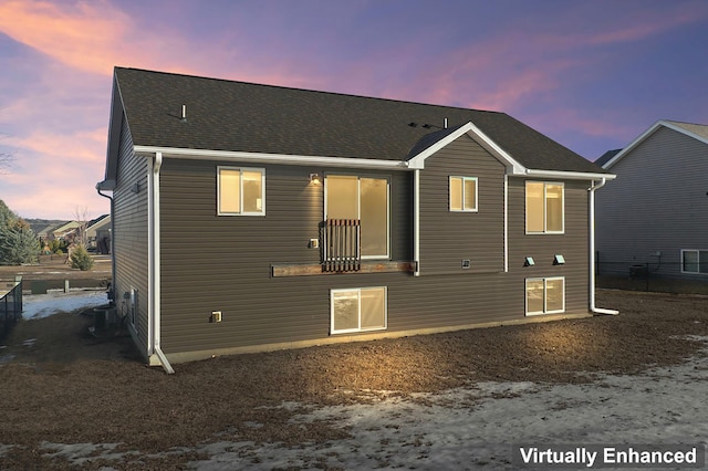 rear view of house with a shingled roof