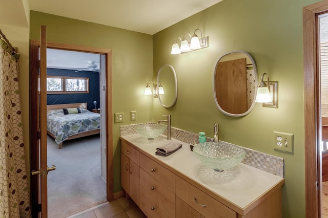 full bath featuring double vanity, ensuite bath, a sink, and tile patterned floors