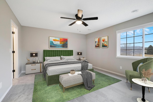 carpeted bedroom with ceiling fan and baseboards