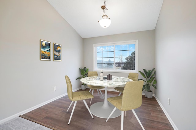 dining room with baseboards, vaulted ceiling, and wood finished floors