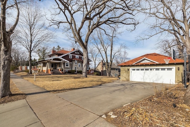 view of front of house with concrete driveway, a chimney, and stucco siding