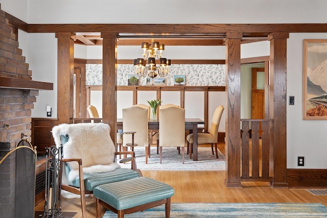 dining area with visible vents, a chandelier, and wood finished floors