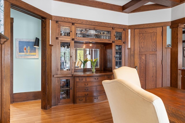 home office with beam ceiling and light wood-style flooring