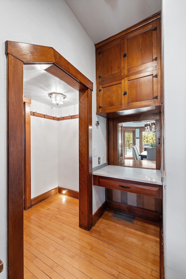 kitchen with light countertops, baseboards, brown cabinets, and light wood finished floors