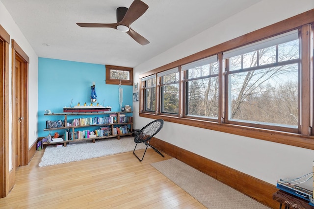 workout area featuring wood-type flooring, plenty of natural light, baseboards, and ceiling fan