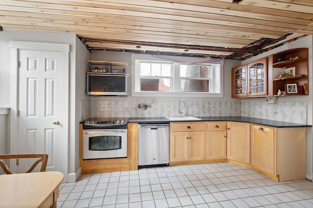 kitchen featuring stainless steel appliances, dark countertops, a sink, and open shelves