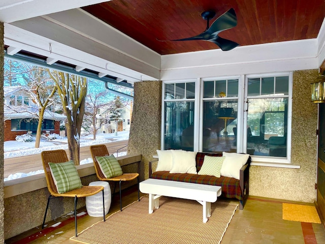 sunroom featuring wooden ceiling and a ceiling fan