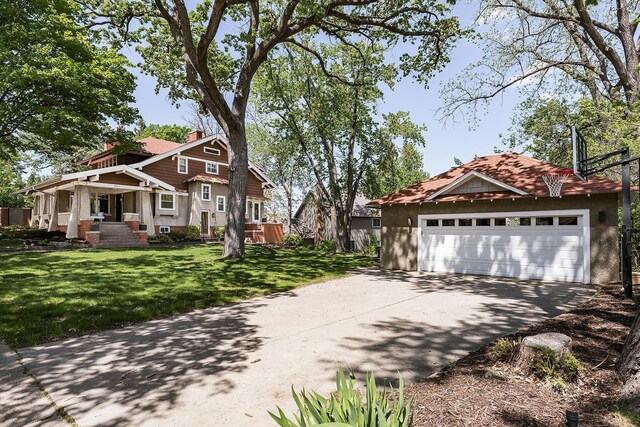 201 2nd St, Excelsior, MN 55331 - view of property exterior with a lawn, concrete driveway, a chimney, and stucco siding